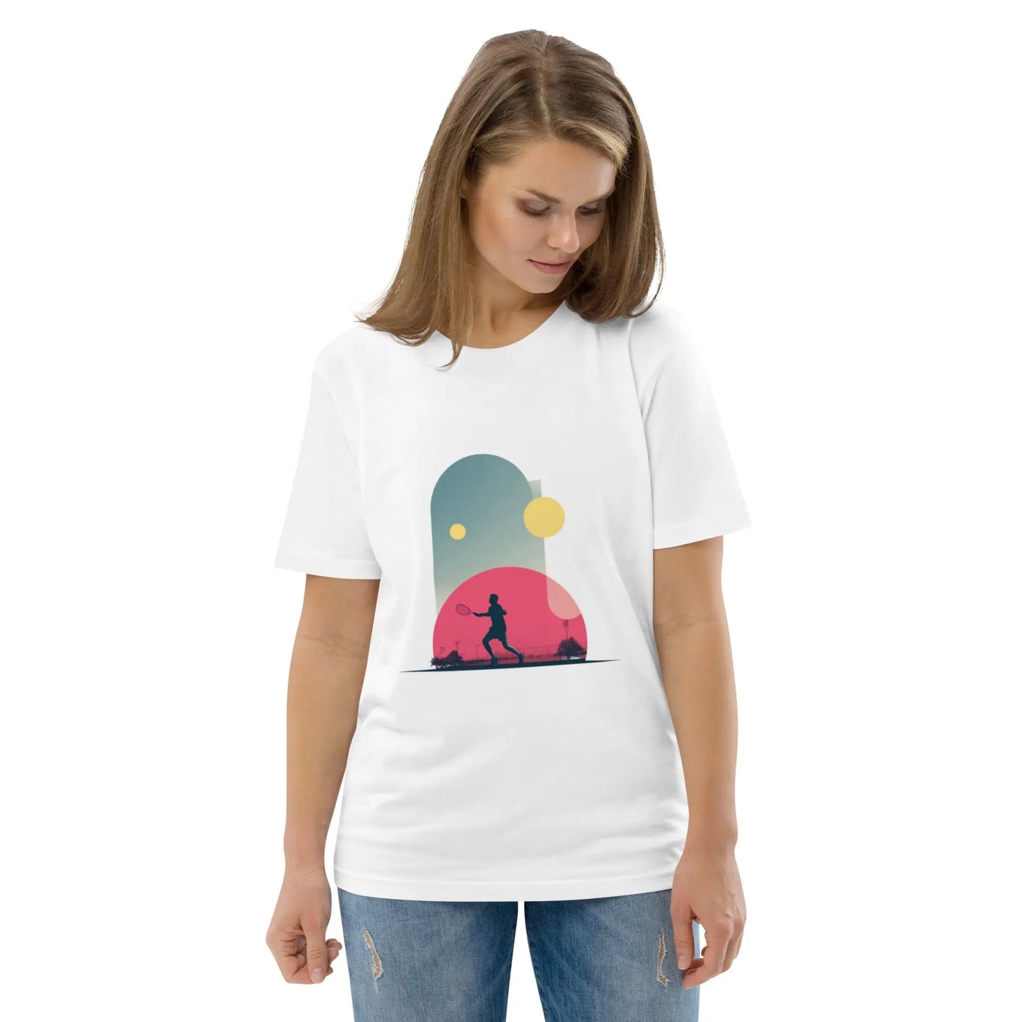 T-shirt adulte blanc en coton bio "Smash Chromatique" avec illustration d’un joueur de tennis en action, couleurs vives rose, bleu et jaune, style graphique dynamique évoquant mouvement et fluidité. La femme qui porte le T-shirt regarde vers le bas.